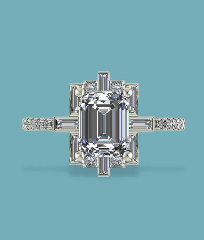 Elegant emerald-cut diamond ring with intricate side detailing, set in white gold. Visit Masterpiece Jewelers in Daytona Beach.