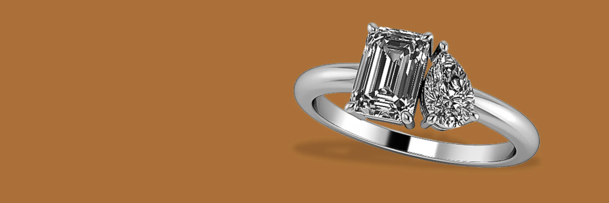 Elegant silver ring featuring an emerald-cut diamond and a pear-shaped diamond, perfect for engagement. Click to start a project