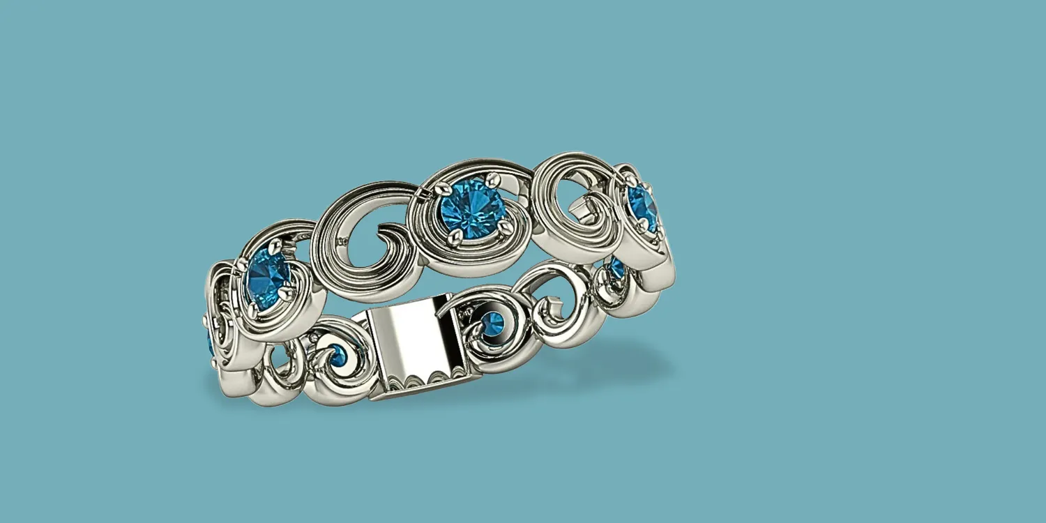 Silver ring with swirling design and blue gemstones, showcasing elegance and style. Visit Masterpiece Jewelers in Daytona Beach.