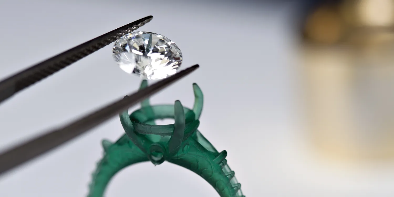 Hands working on a ring with tools, showcasing craftsmanship at Masterpiece Jewelers. Click to learn about remounting & redesign