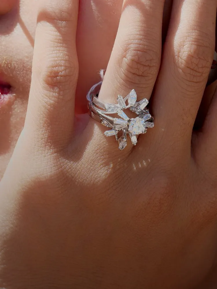Elegant engagement ring on model's hand, with a diamond centerpiece. Visit Masterpiece Jewelers for more details.