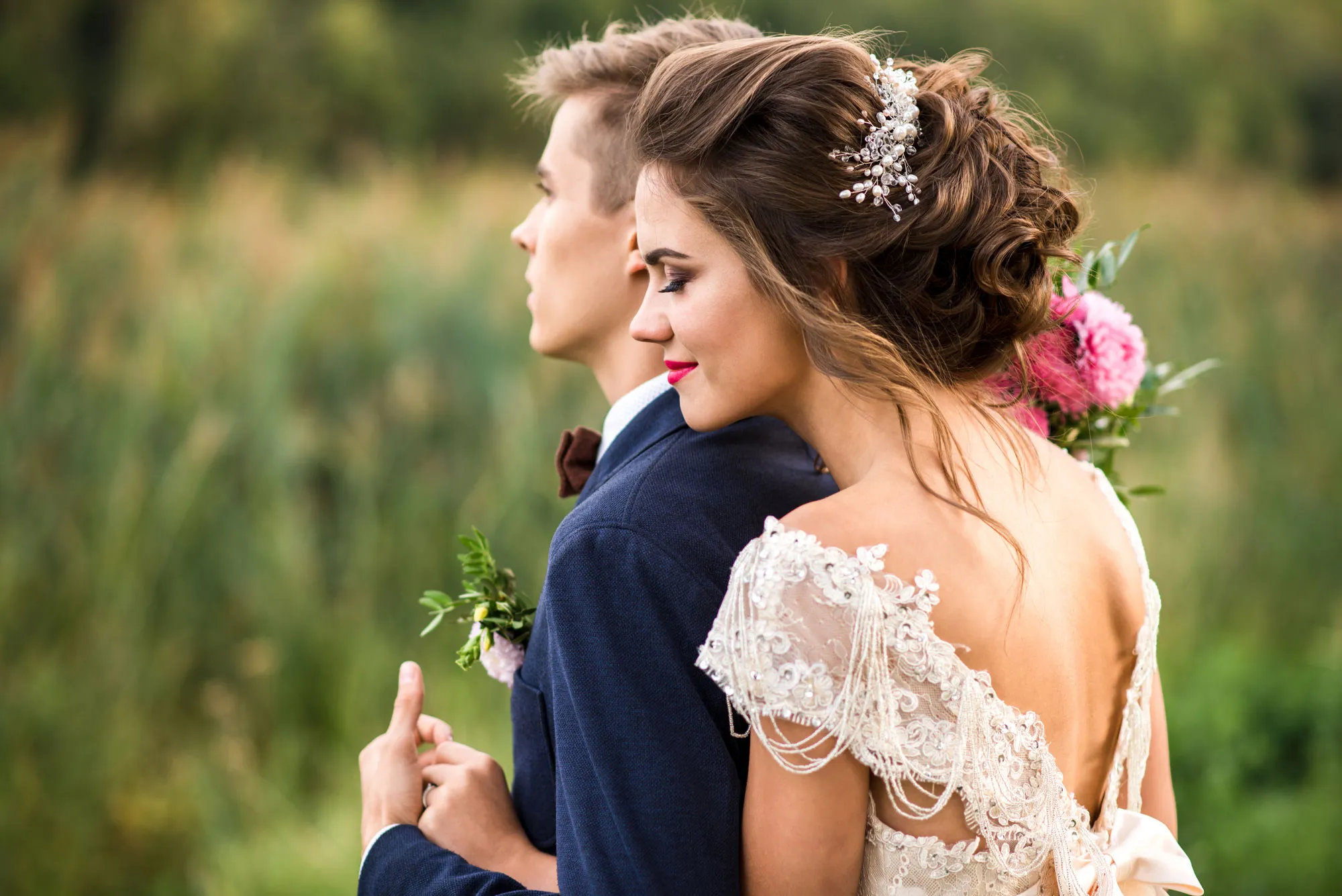 Bride embracing groom in a romantic outdoor setting, showcasing love and elegance. Visit Lee Ann's Fine Jewelry for engagement r