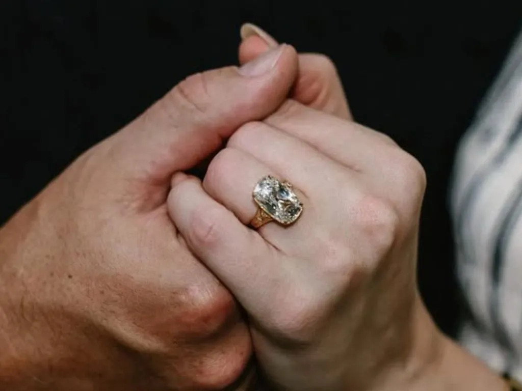 Close-up of hands with engagement ring.