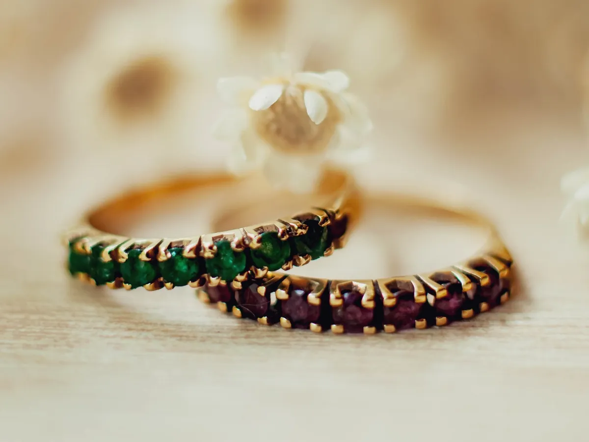 Two gold rings featuring colorful gemstones.