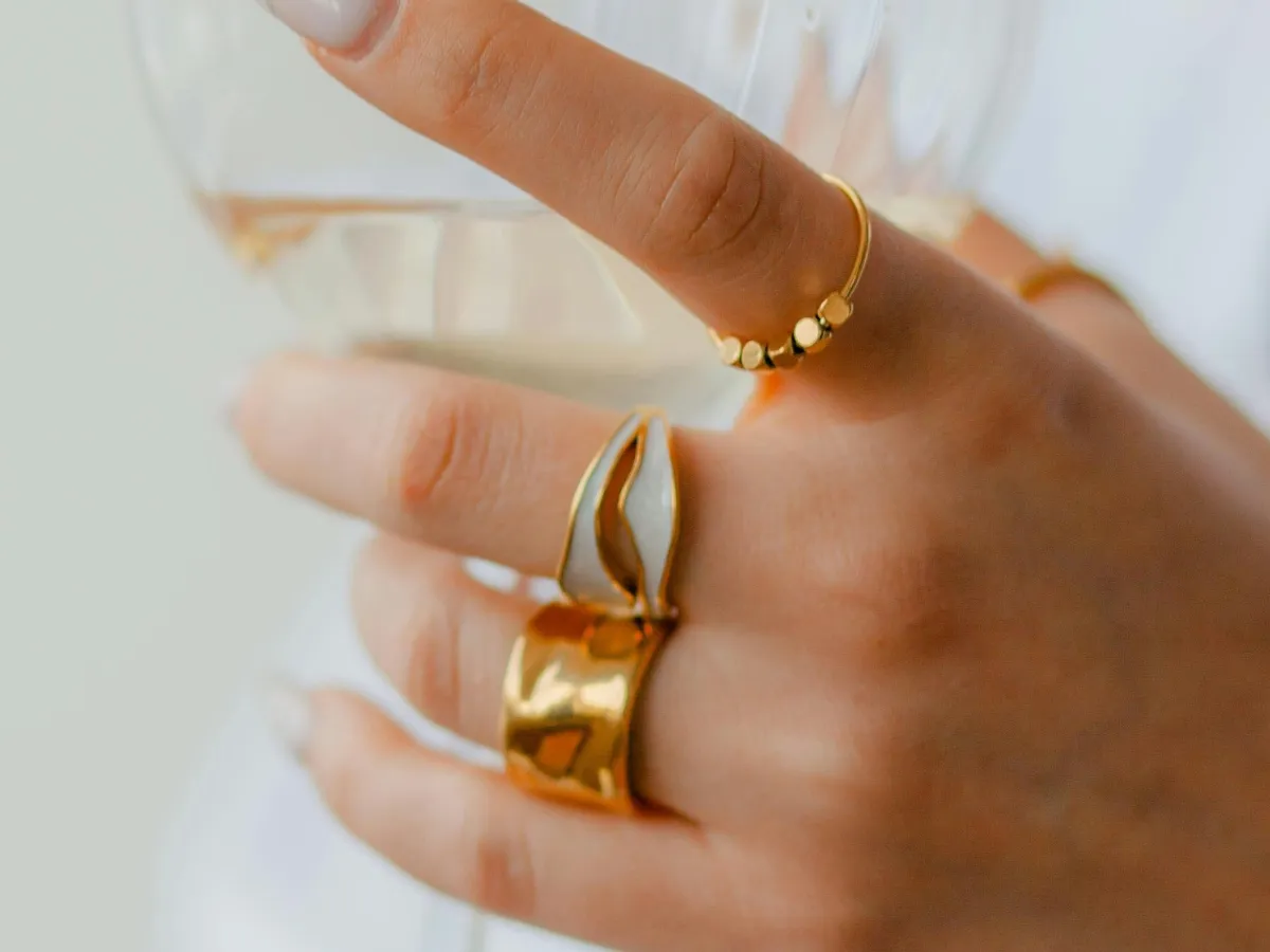Woman wearing modern chunky gold rings.