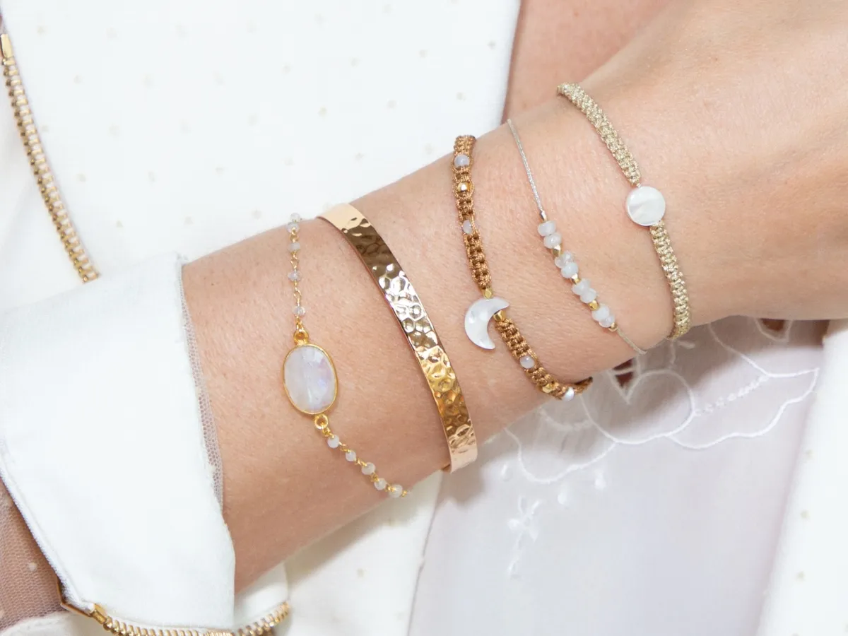 Stacked minimalist gold and gemstone bracelets.