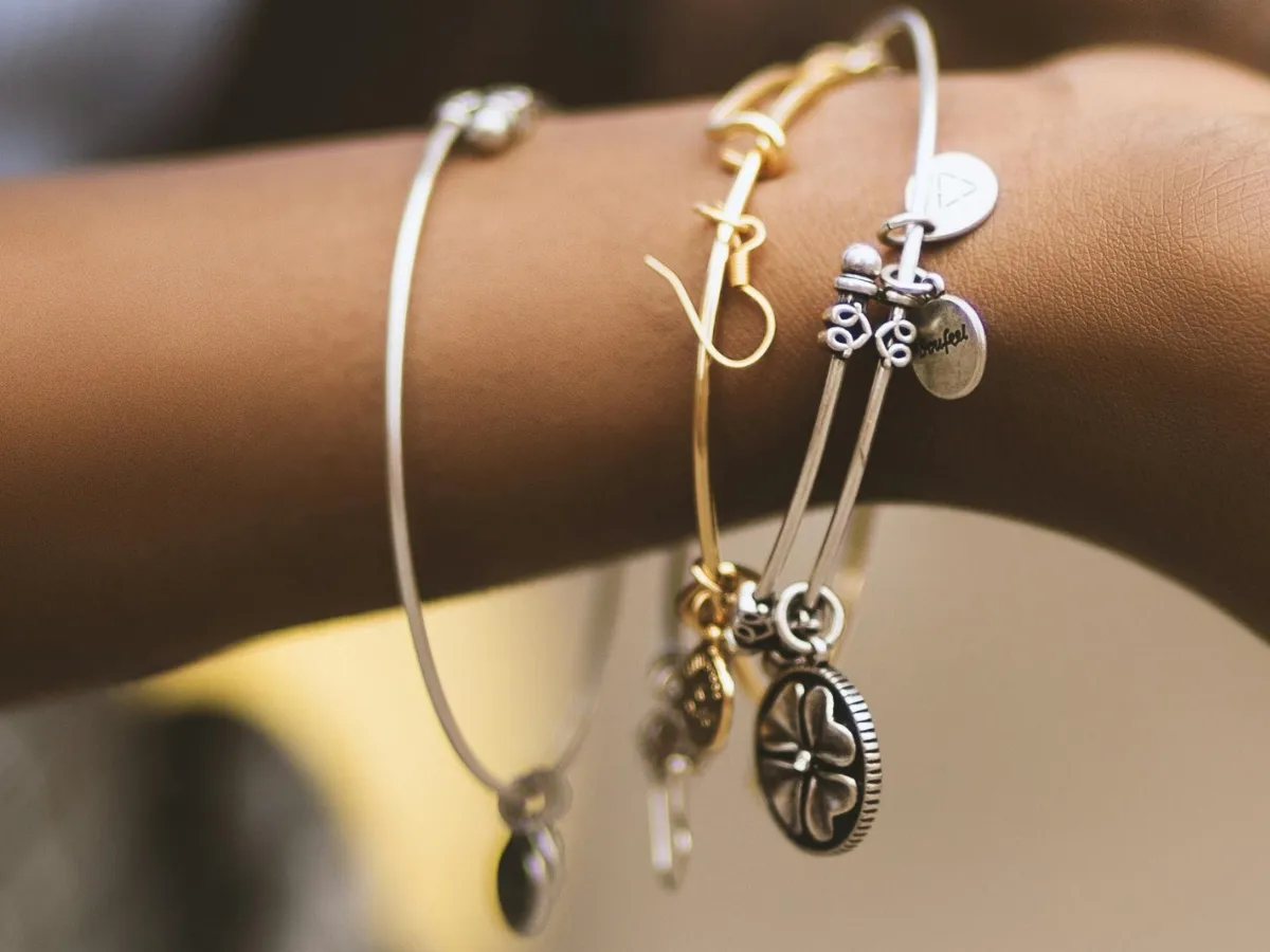 Stacked metal charm bangle bracelets.