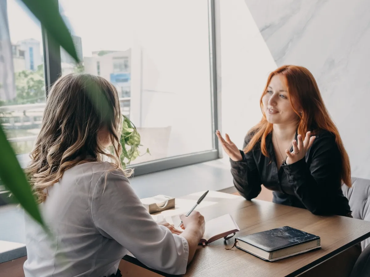 Two women having a discussion indoors.