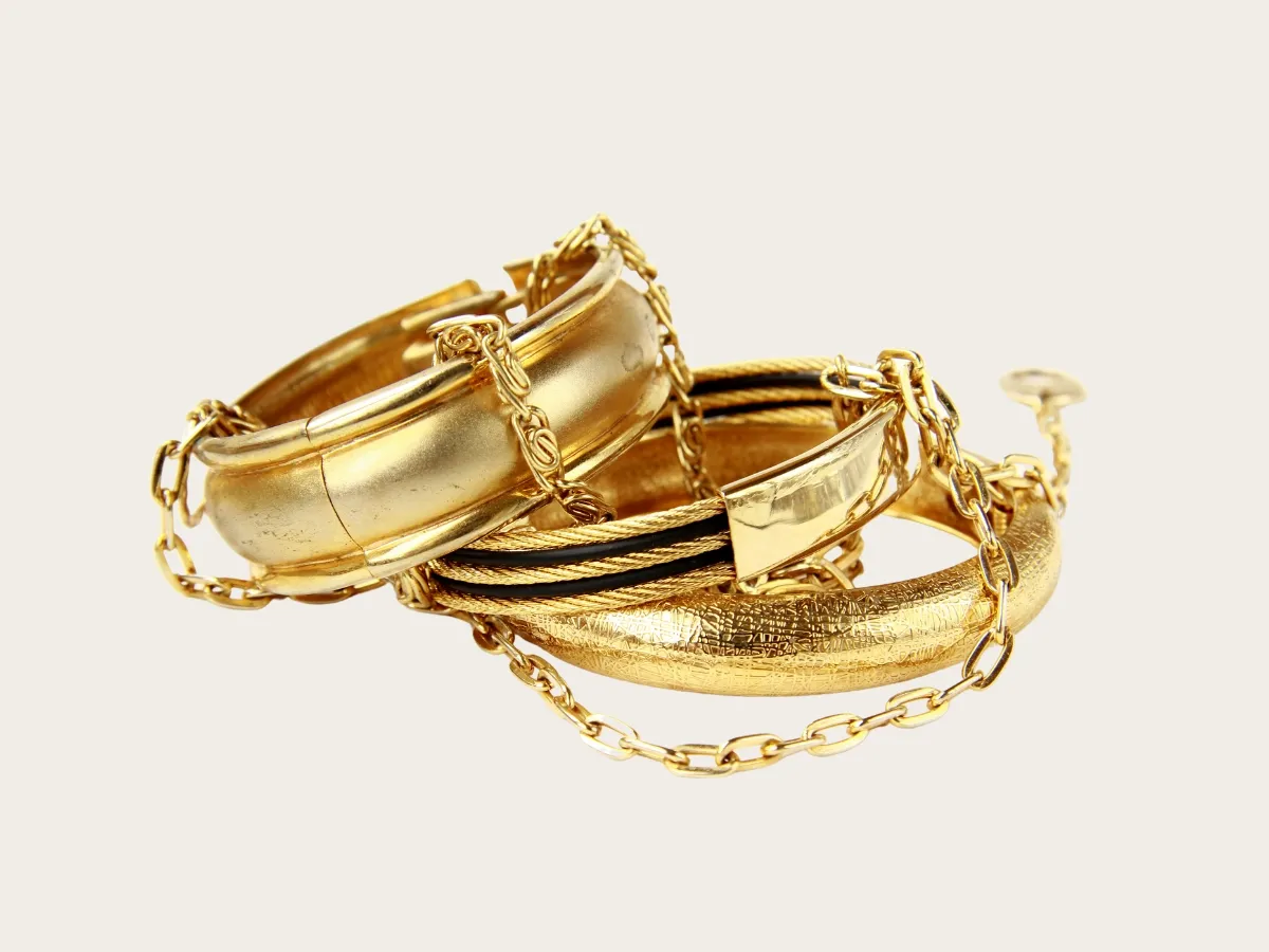 Stack of gold bangles with chains.