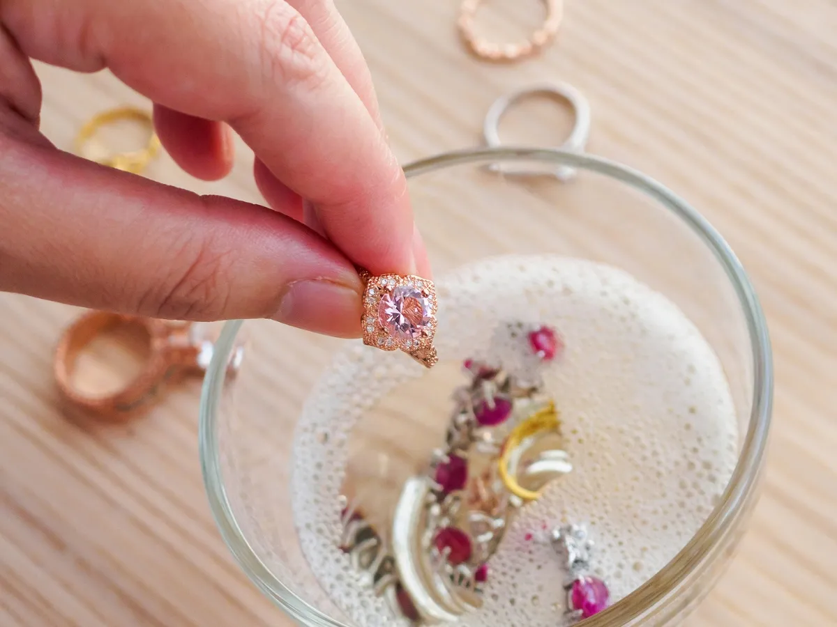 Hand cleaning ring in soapy water.