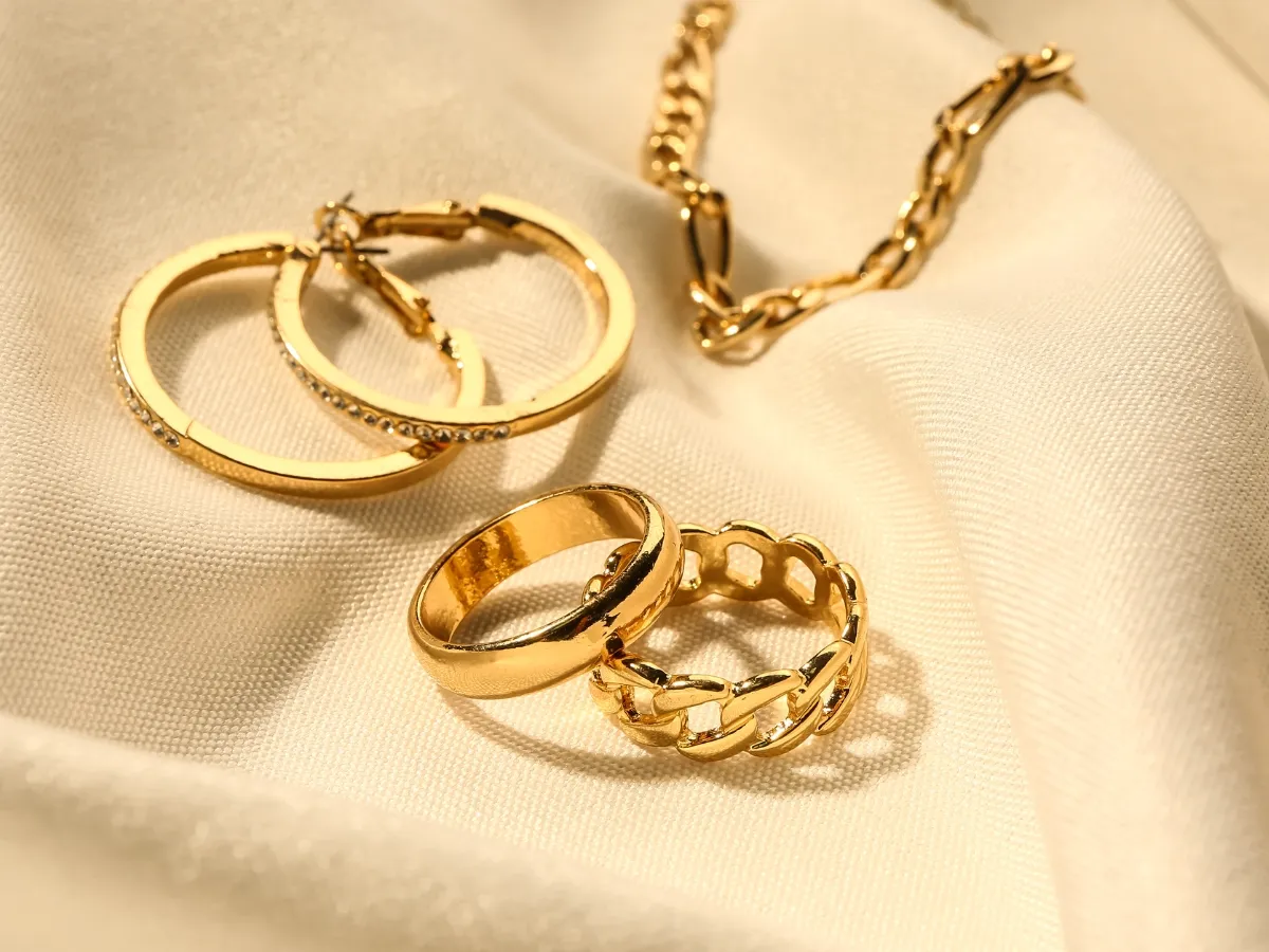 Gold rings and necklace on fabric.