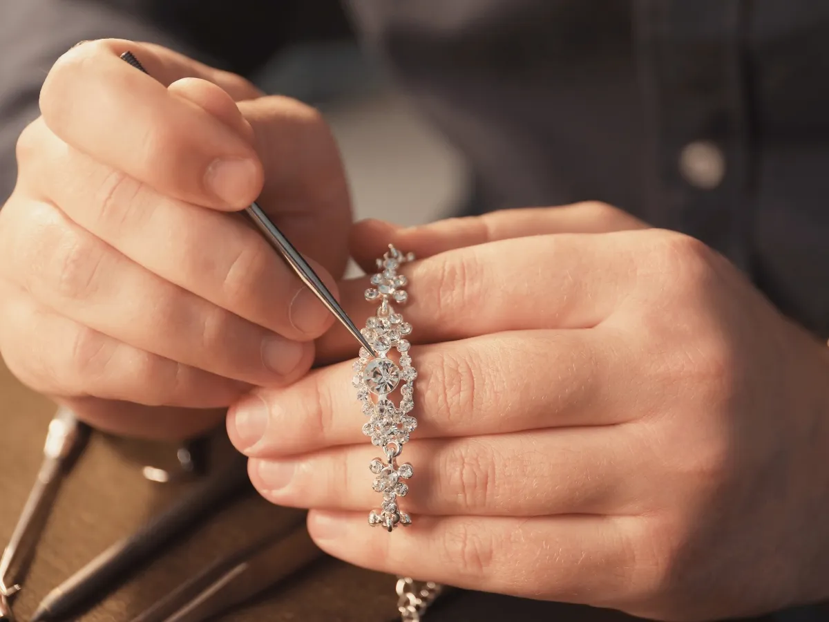 Jeweler setting stones in bracelet.