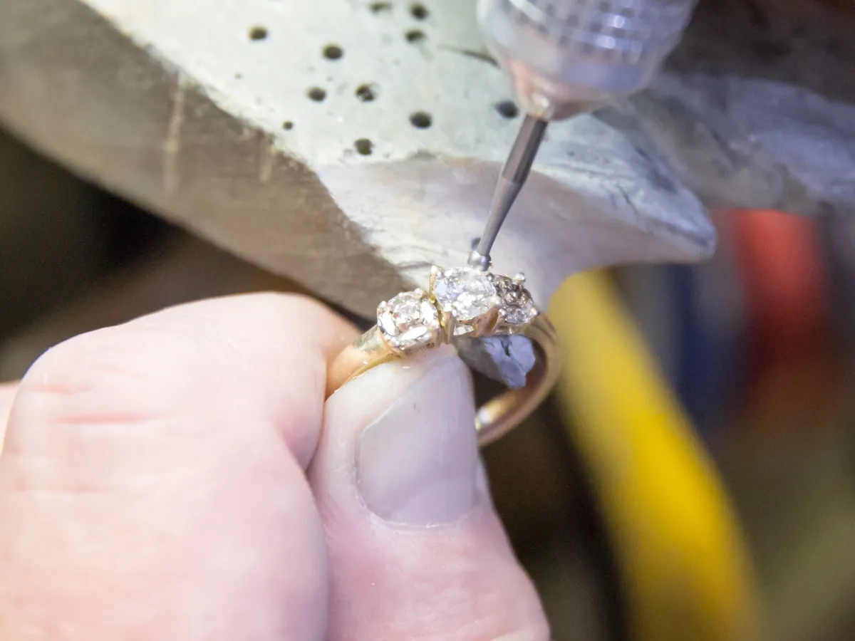 Jeweler repairing diamond ring setting.