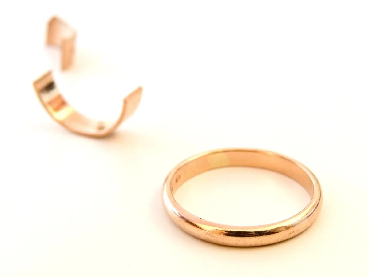 Broken gold ring on white.