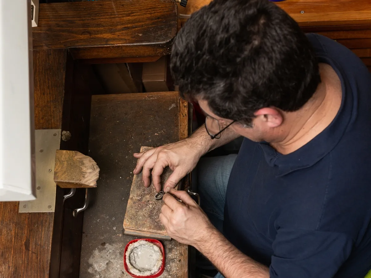 Craftsman working on ring at bench.