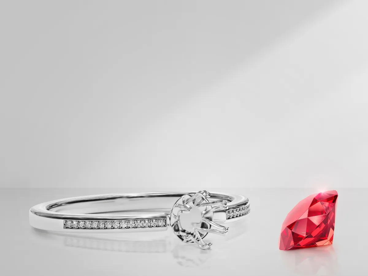 Ruby gemstone beside diamond ring.