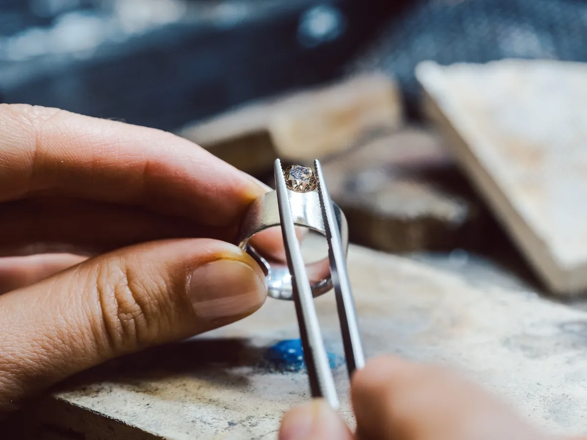 Placing gemstone into silver ring.
