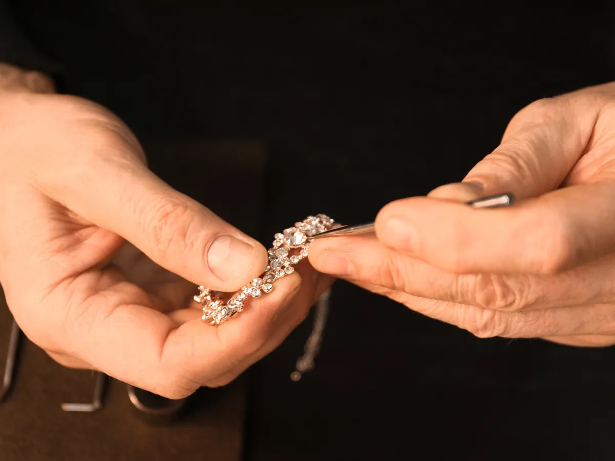 Jeweler crafting diamond necklace close-up.