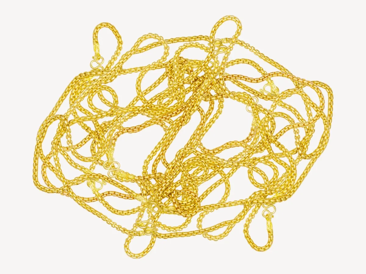 Multiple tangled thin gold chains.