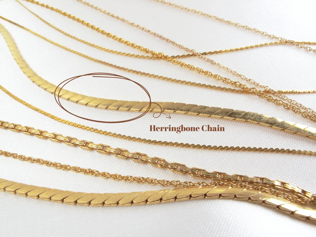 Gold herringbone chain among various necklaces.