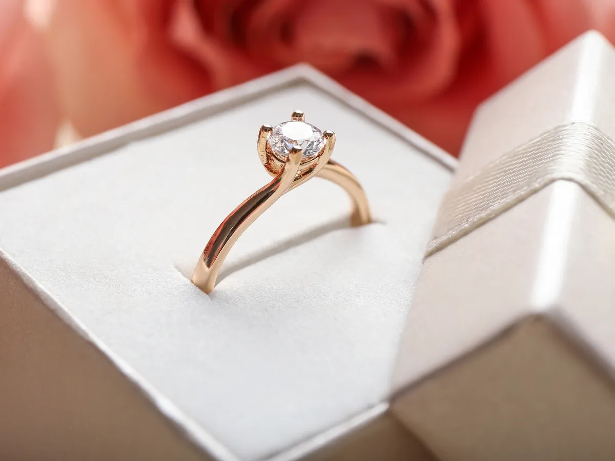 Rose gold engagement ring in box.