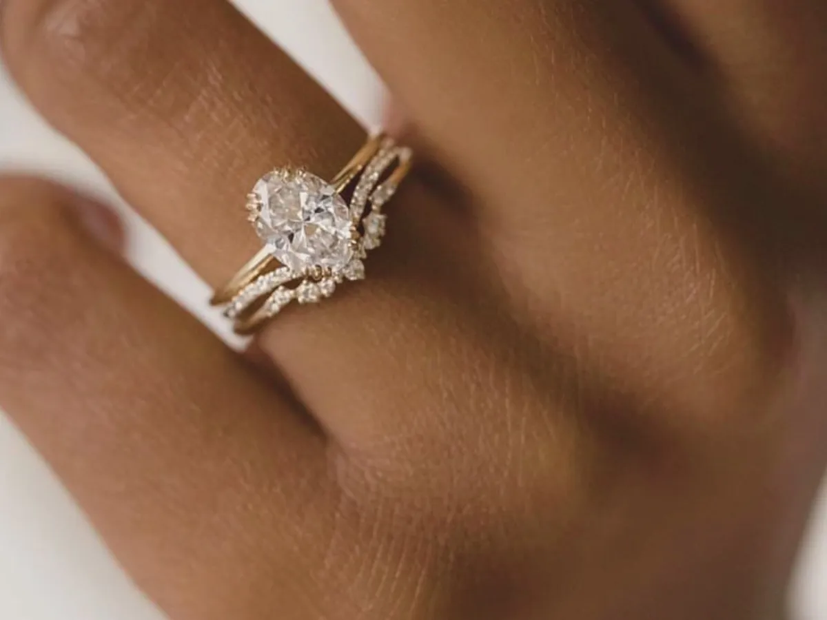 Oval diamond ring with pavé band.