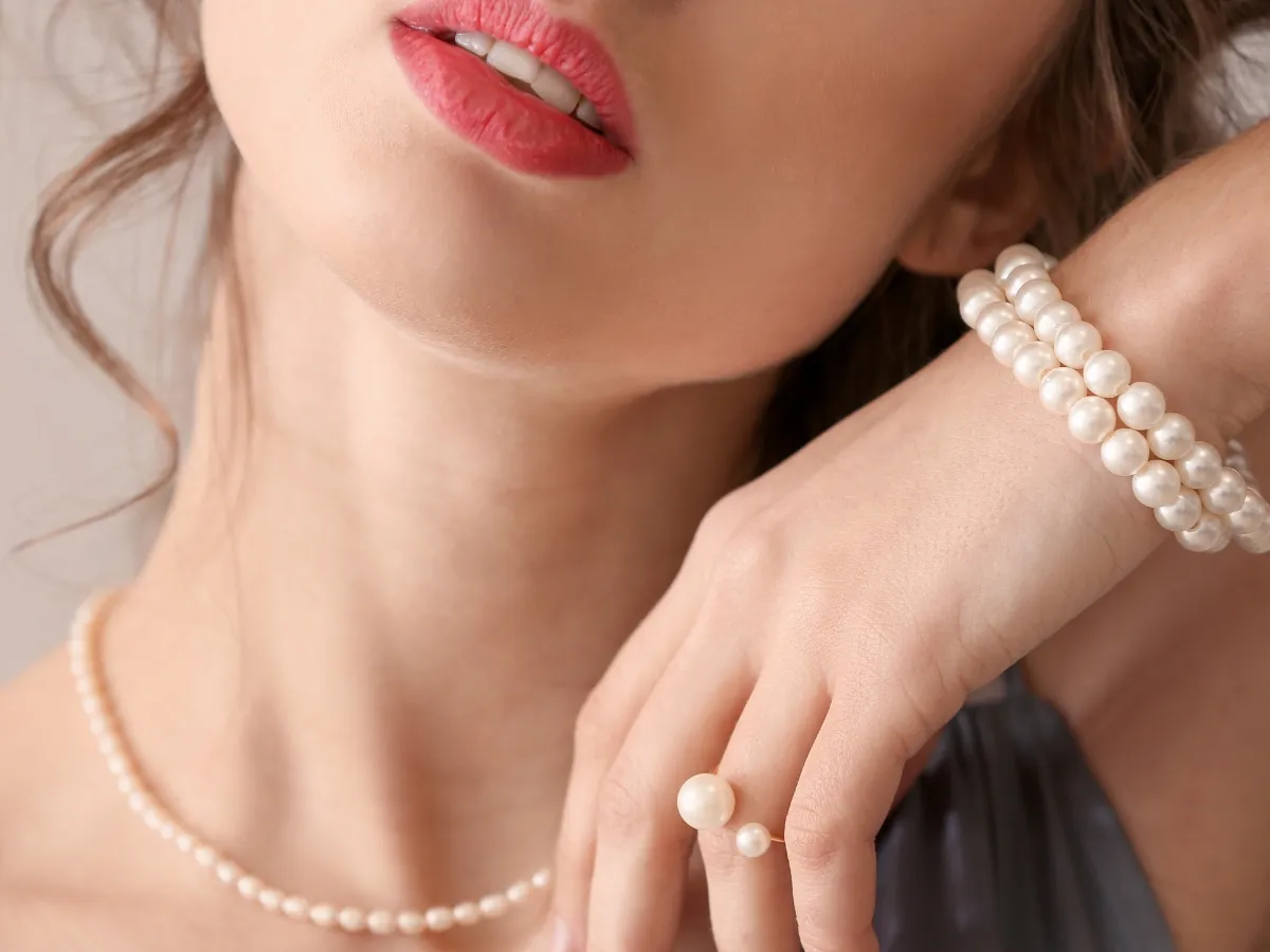 Close-up of woman wearing pearl jewelry.