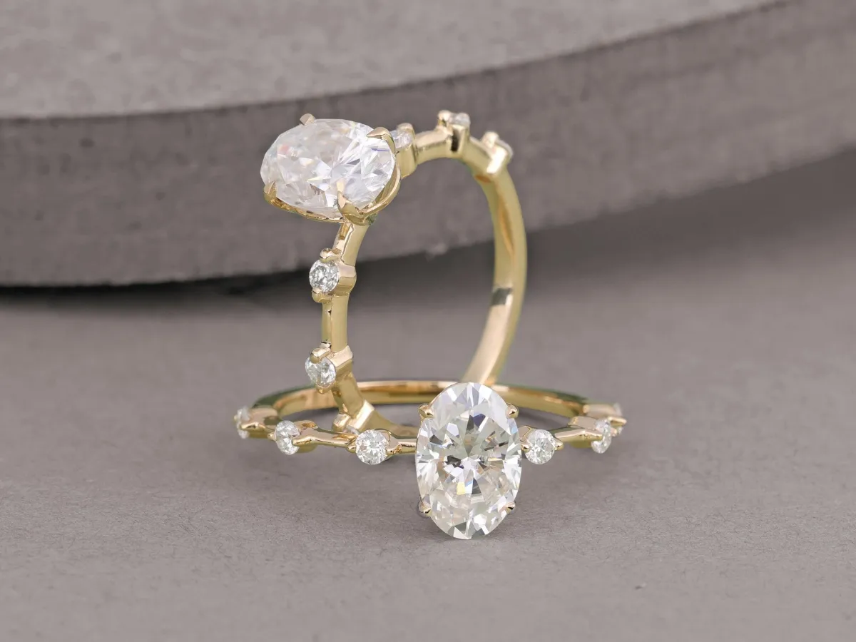 Two elegant rings with oval-cut diamonds set in a yellow gold band.