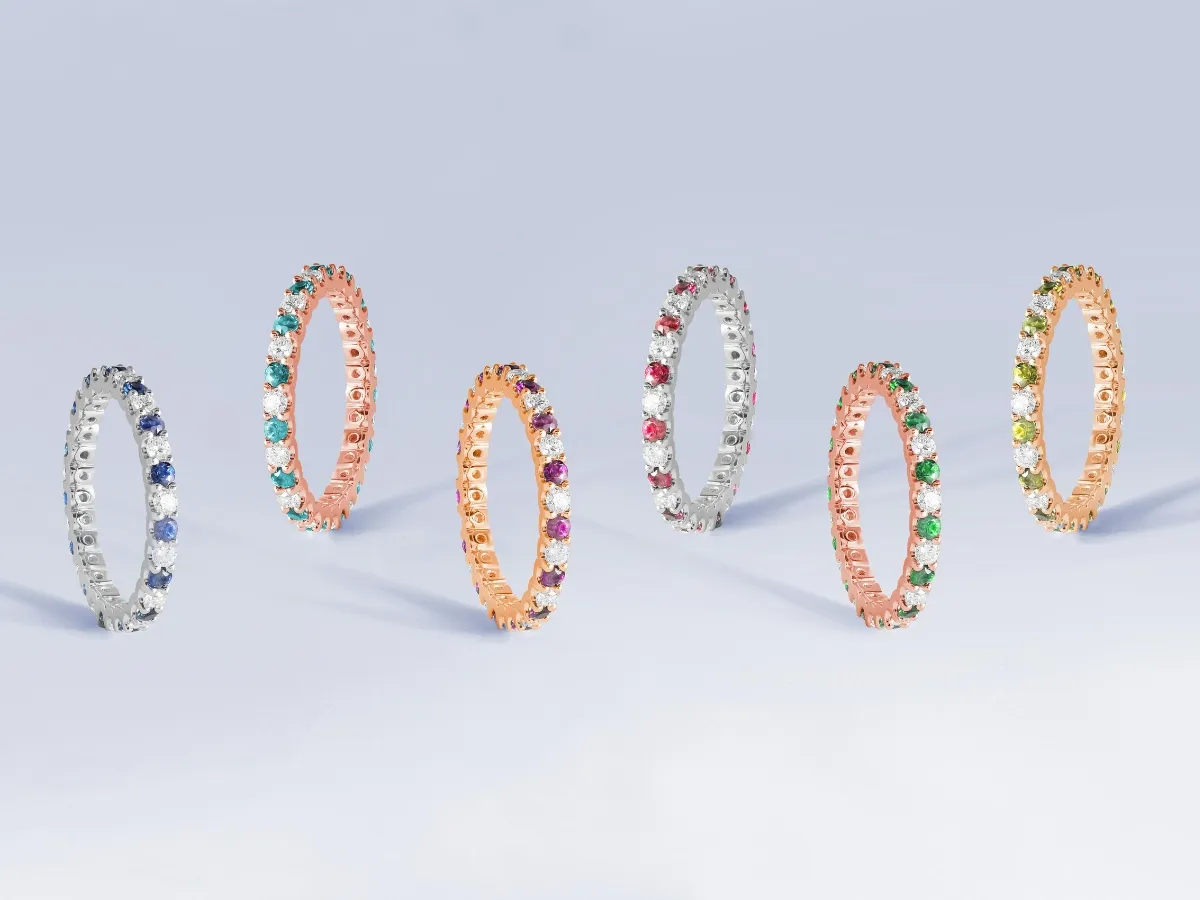 Colorful gemstone eternity rings in gold settings.