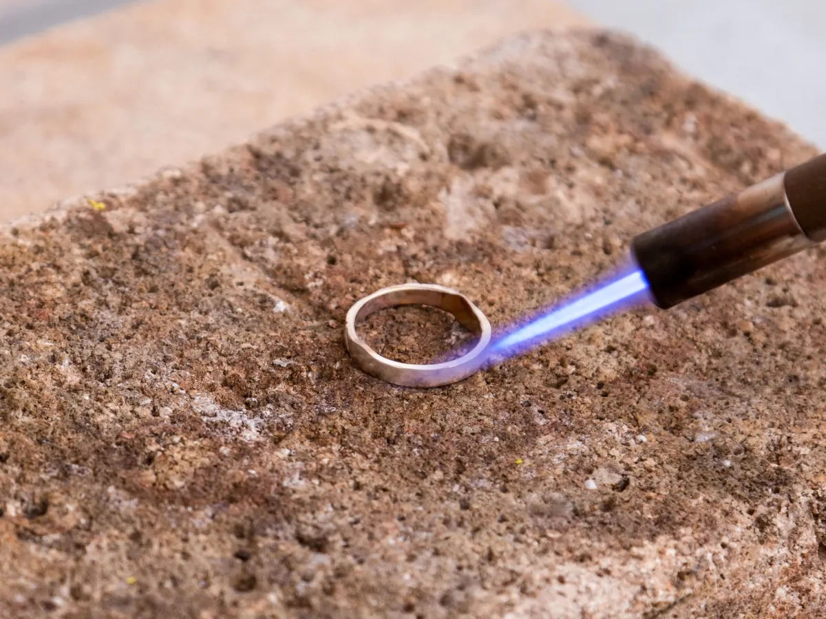 Ring being soldered with blue flame.