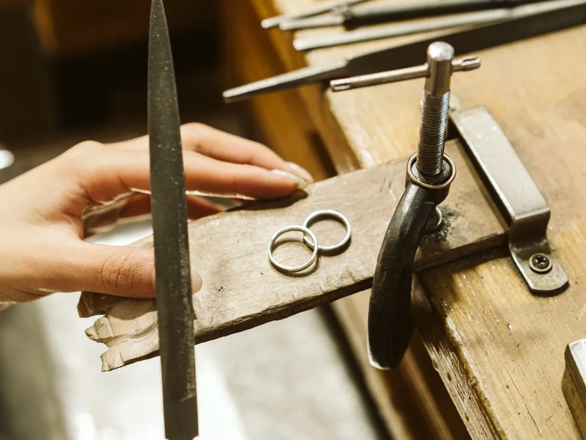 Jeweler filing rings on bench.