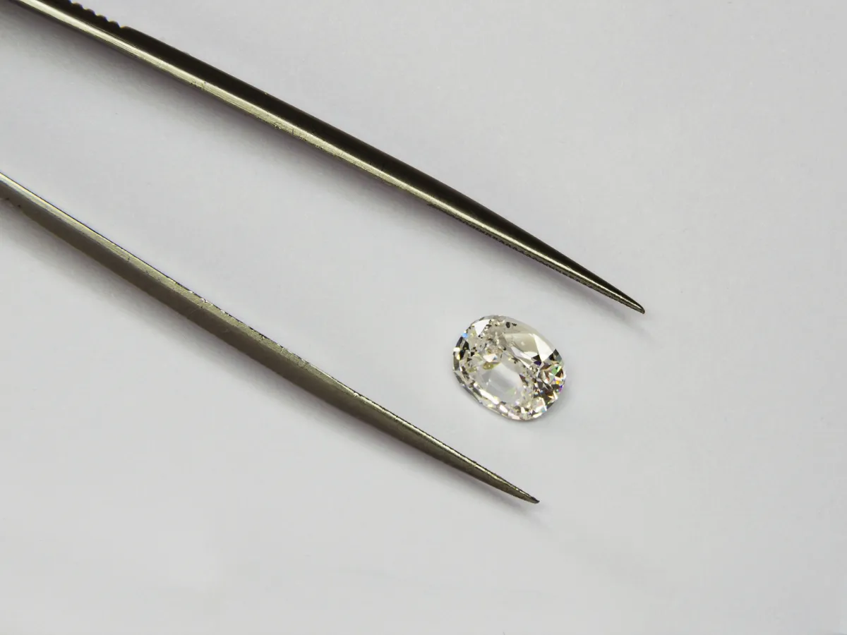 Oval cut diamond with tweezers.