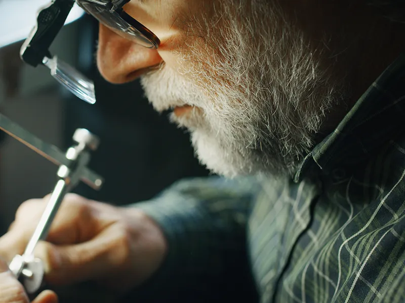 A skilled jeweler diligently working on a delicate piece of jewelry.
