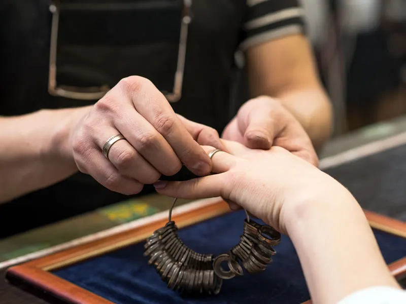 Jeweler sizing a woman's ring finger. Van Adams Jewelers Snellville, GA