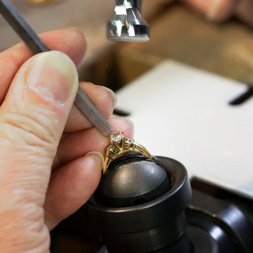 A jeweller carefully setting a diamond in a gold ring during a repair at Vandenbergs Fine Jewellery in Winnipeg.