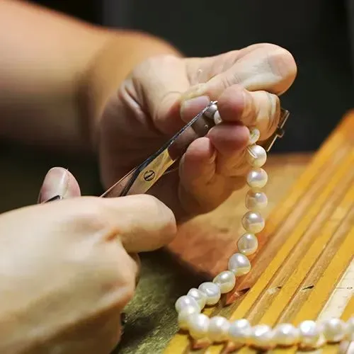 A jeweller restringing a pearl necklace at Vandenbergs Fine Jewellery in Winnipeg.