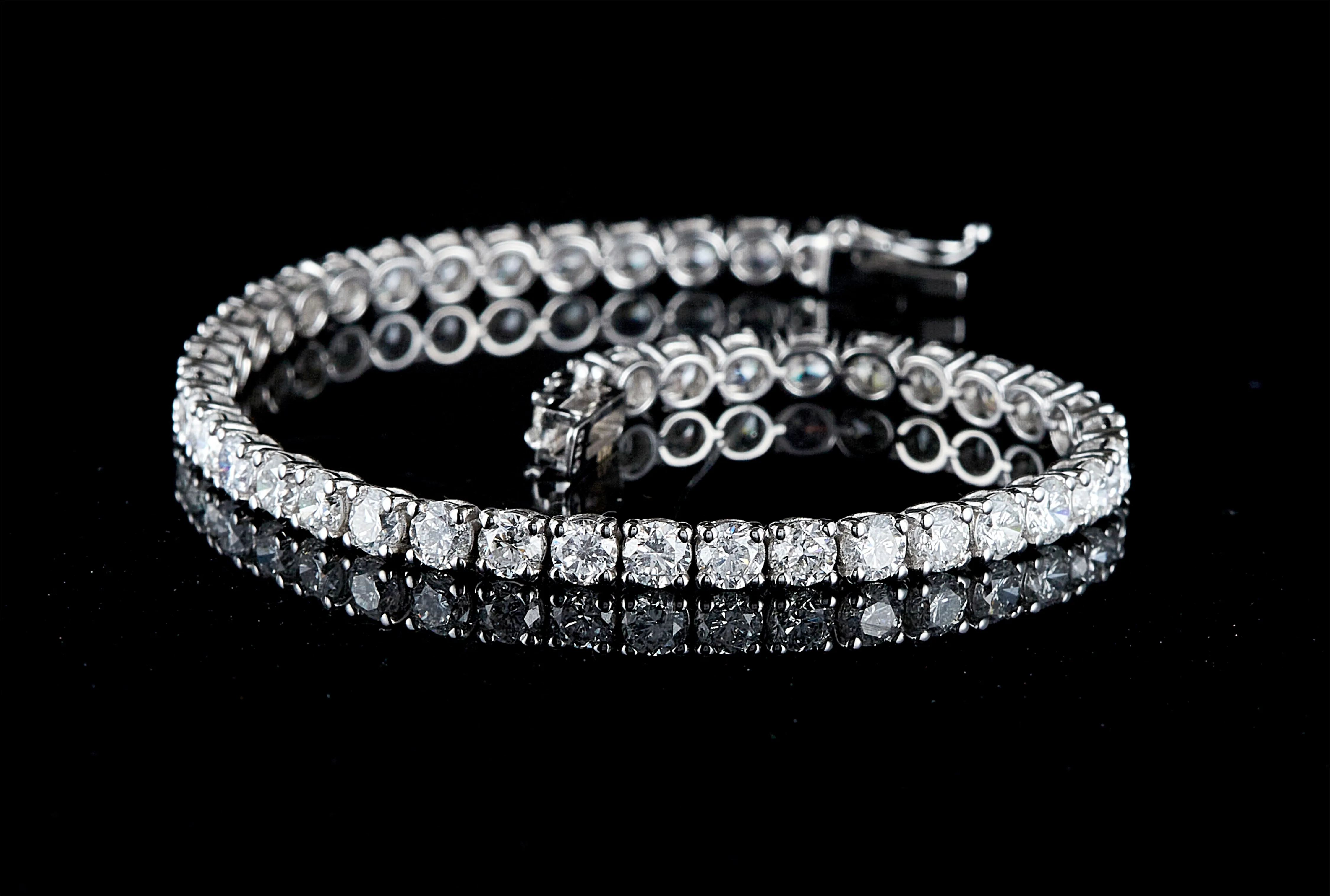 Stoneless ring laying flat with multiple colored stones and a loose pendant scattered next to it