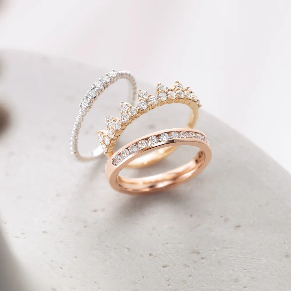 Three diamond rings, each a different metal type with silver, gold, and rose gold being represented