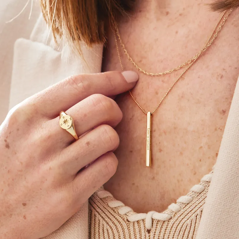 Woman wearing engraved necklace and engraved signet ring 