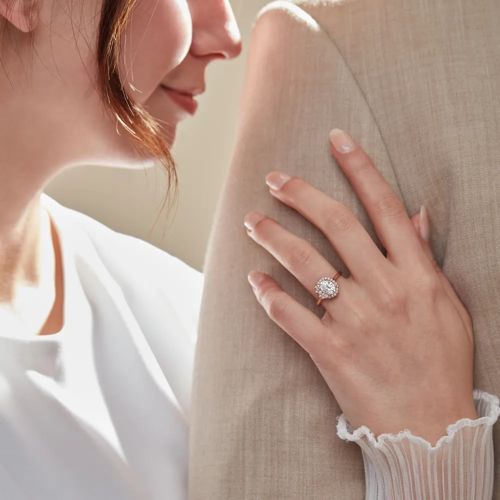 Woman holding man and showing off her oval diamond engagement ring