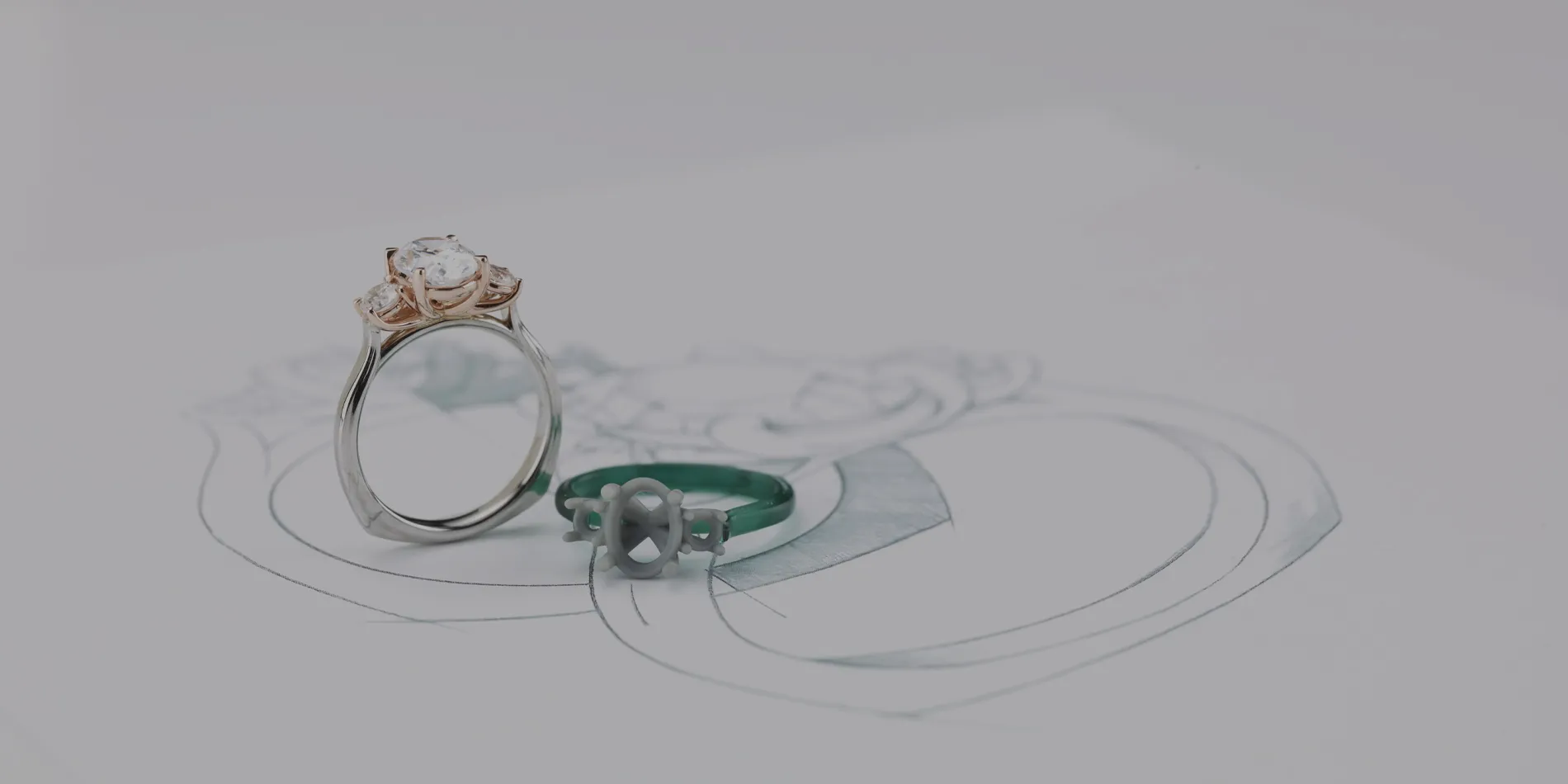 Final three stone engagement ring with the mold laying on top of the ring sketch