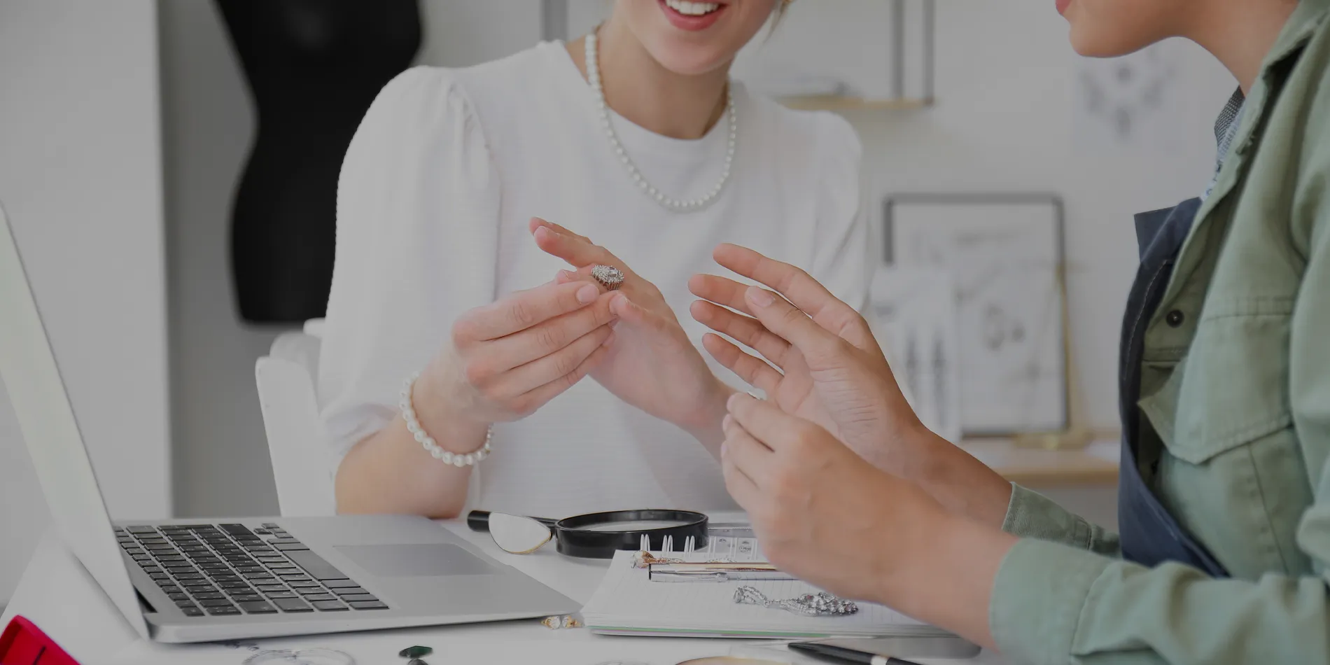 Woman holding a ring in front of a laptop talking with someone