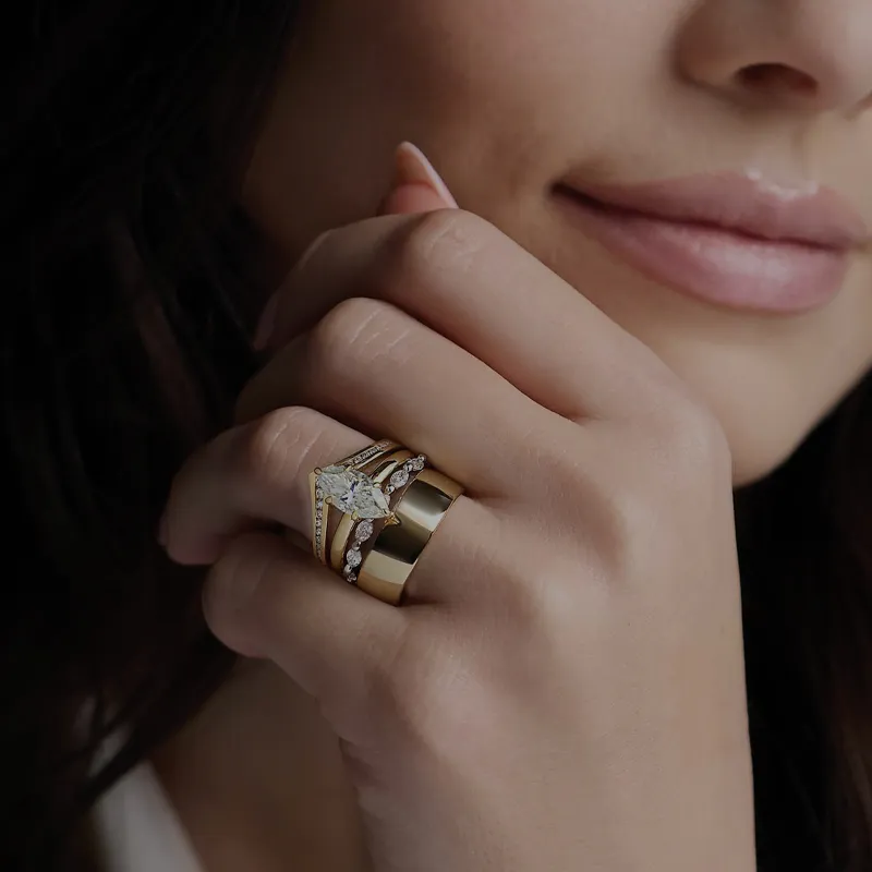Woman wearing an engagement ring and thick wedding band