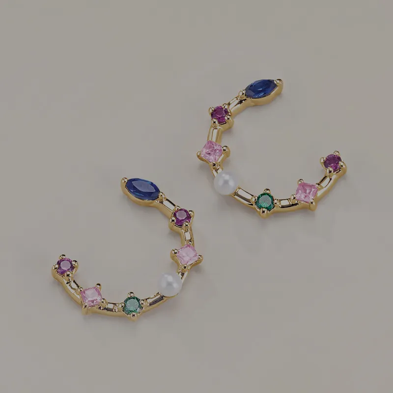 Colorful gemstone hoop earrings on tan background