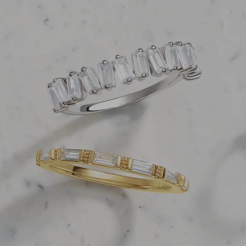 Gold and silver diamond rings on marble surface