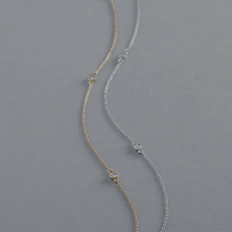 Gold and silver necklace laying on gray surface