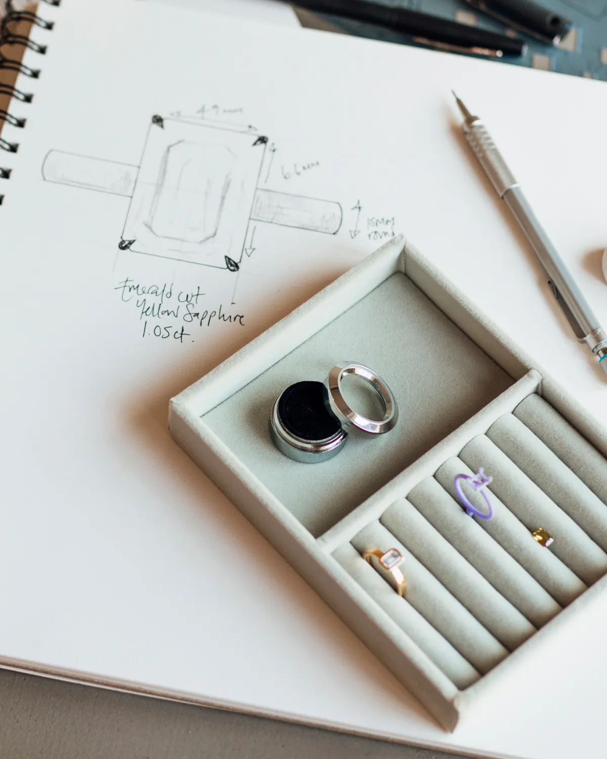 Sketch of a ring design with a jewelry box containing rings and tools.