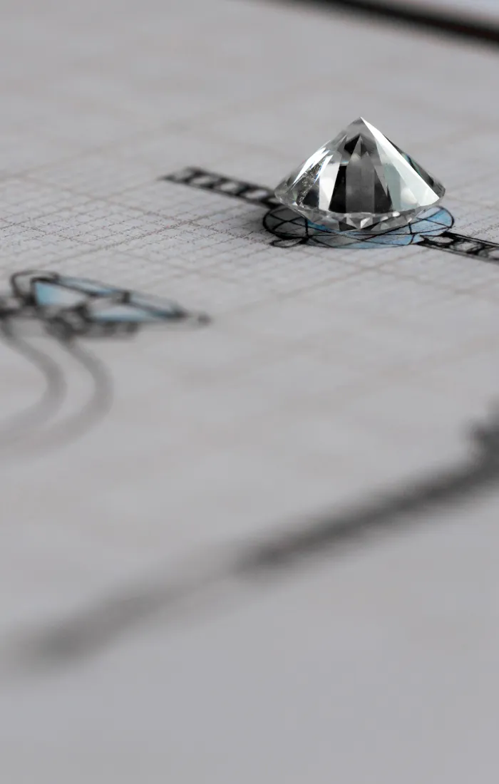 Diamond on grid paper with jewelry design sketches.