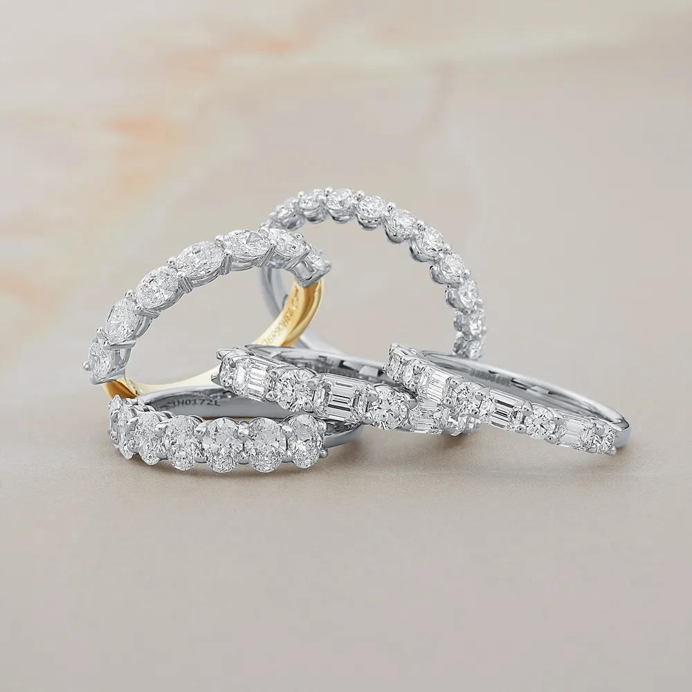 Diamond wedding bands in various styles on a neutral background.