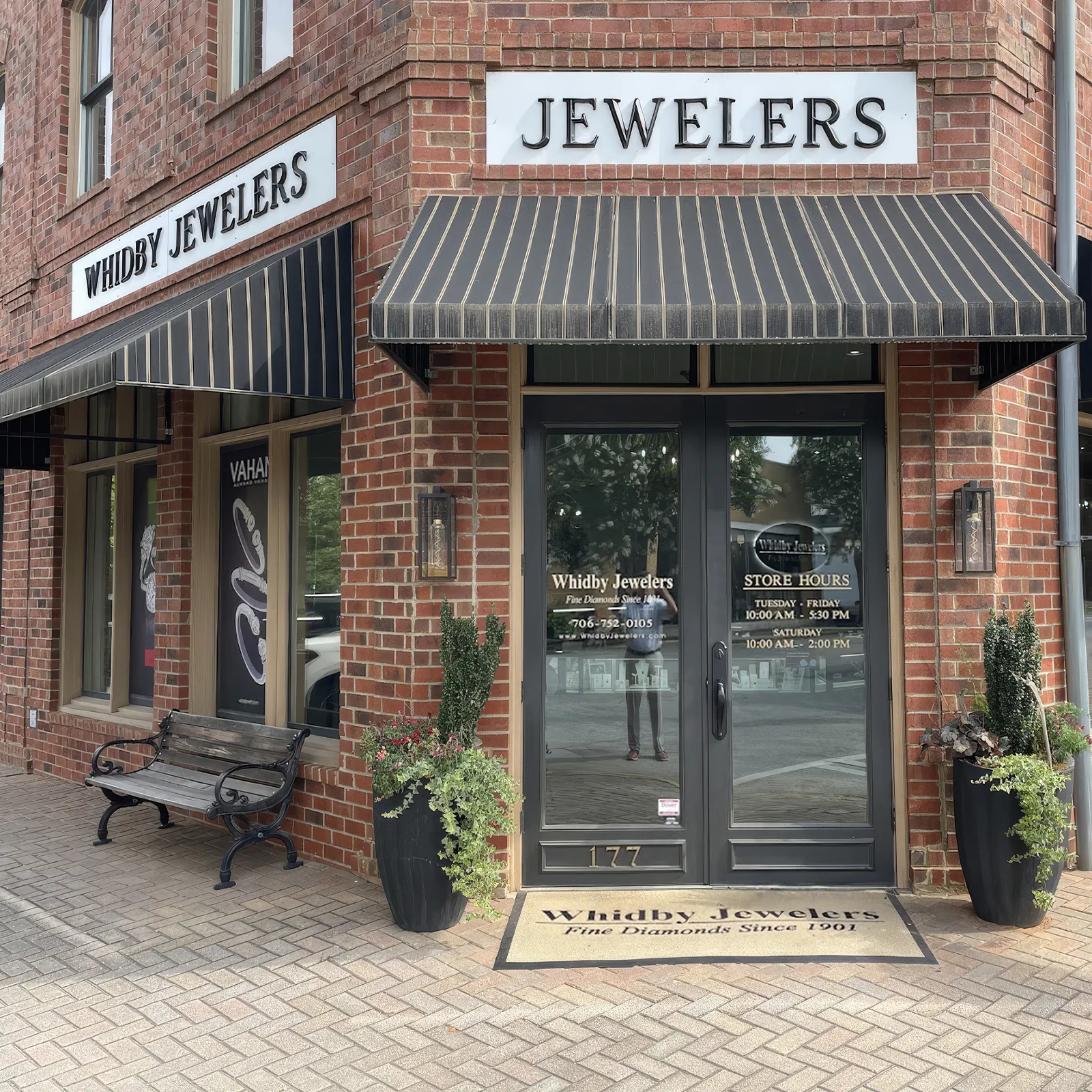 Brick jewelry store exterior with striped awnings, 